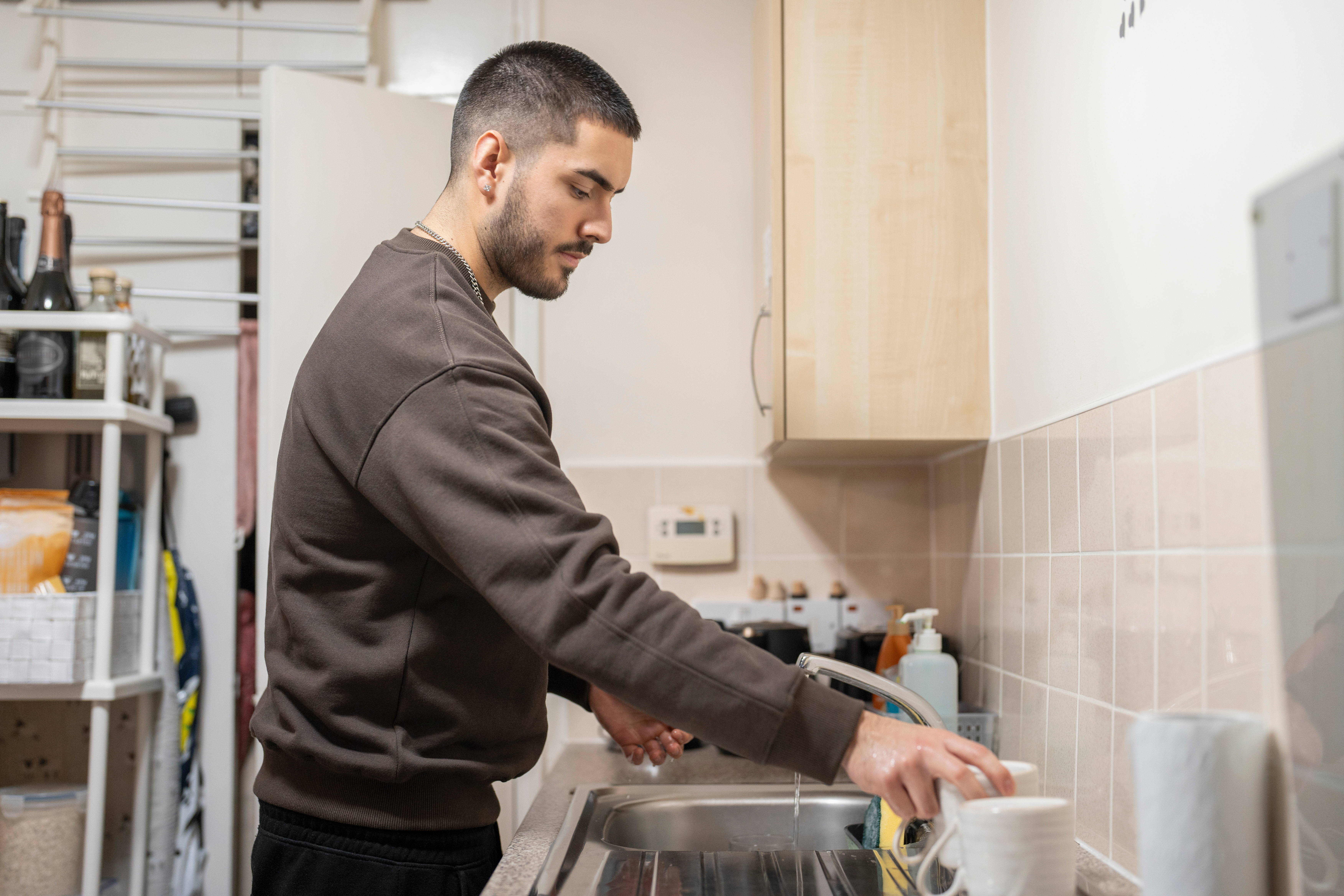 Young man using a kitchen sink